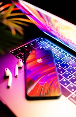 an iphone on a macbook with dramatic lighting